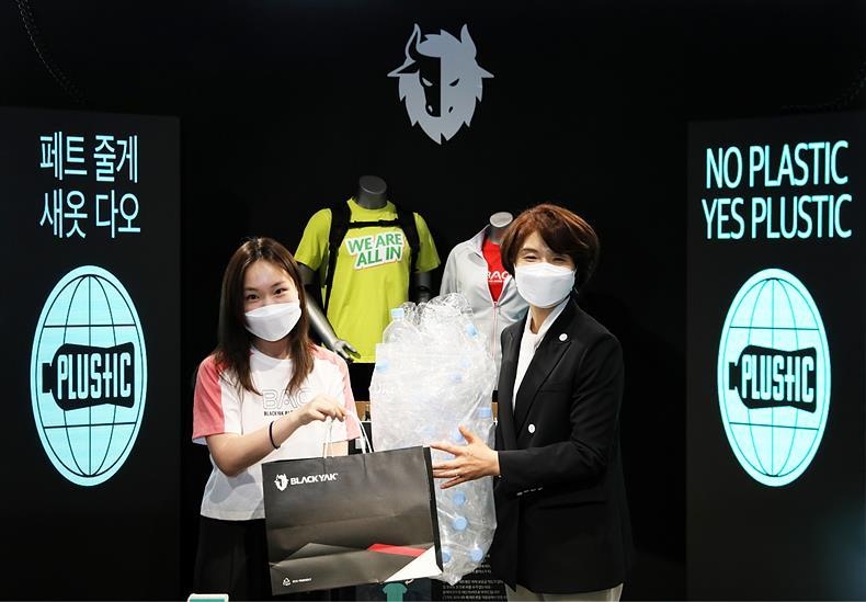 한정애 환경부 장관(사진 오른쪽)이 지난 26일, 서울 서초구 블랙야크 양재점서 열린 ㈜비와이엔블랙야크가 진행하는 친환경 캠페인 '페트 줄게, 새옷 다오' 행사에 참여해 페트병 15개로 블랙야크 티셔츠로 교환받고 있다. 