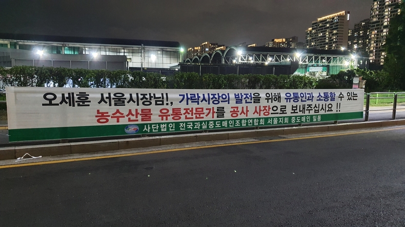 지난 18일, 가락몰 앞 대로변에 (사)전국과실중도매인조합연합회 서울지회 관계자들이 설치한 플래카드가 걸려 있다.