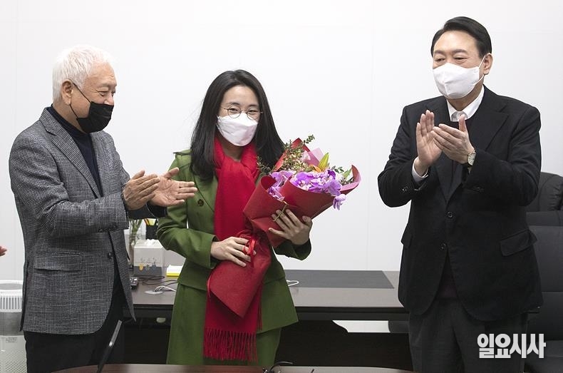 국민의힘 윤석열 대선후보 직속 새시대준비위원회에 합류한 신지예 한국여성정치네트워크 대표(사진 가운데)가 꽃다발을 받아들고 있는 가운데 김한길 새시대위원장(왼쪽)과 윤 후보가 손뼉을 치고 있다. ⓒ고성준 기자