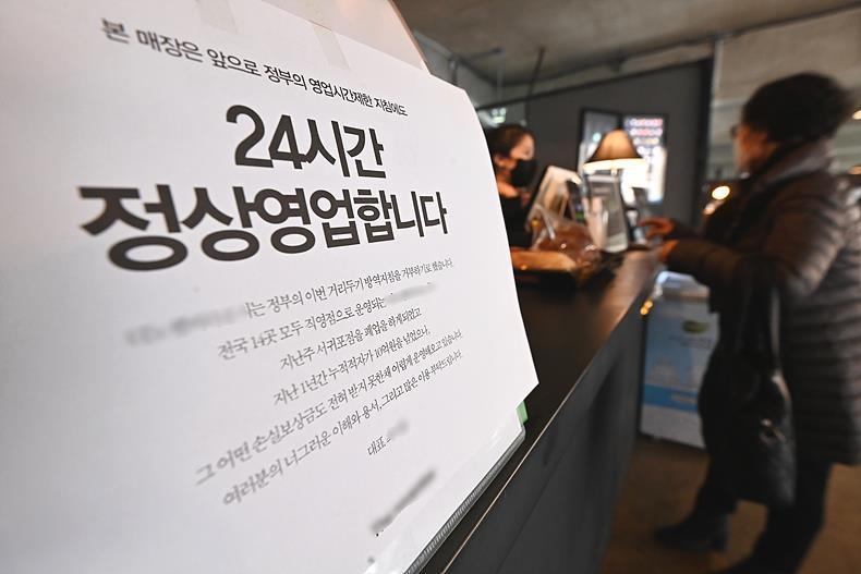 정부의 방역지침을 거부하고 24시간 영업을 한다는 안내문 내 건 한 음식점 ⓒ뉴시스 