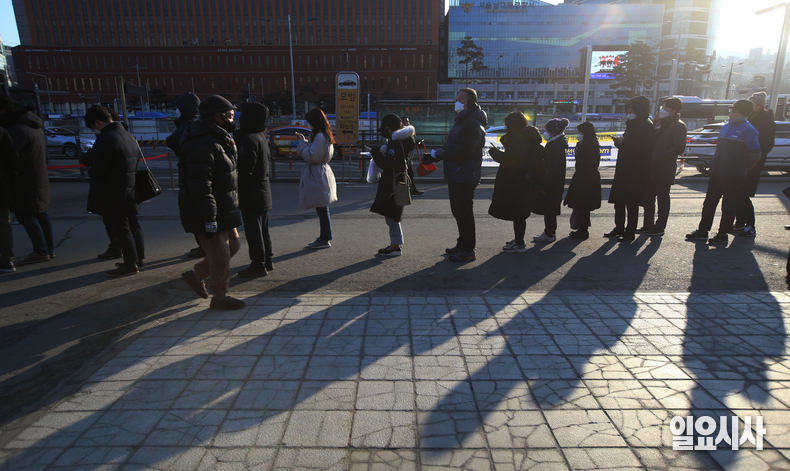 최근 코로나 신규 확진자가 20만명을 넘은 가운데 정부가 4일, 카페·음식점 등 다중이용시설의 영업제한 시간을 밤 10시에서 11시로 완화하는 사회적 거리두기 조정안을 발표했다. 사진은 지난달 16일, 서울역 임시선별검사소에서 시민들이 코로나 검사를 받기 위해 줄지어 대기하고 있는 모습. ⓒ박성원 기자