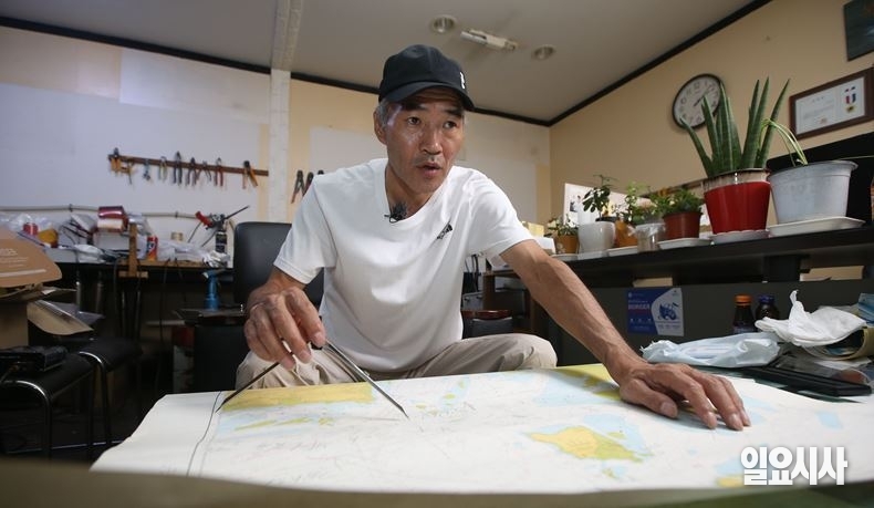 사고지점에 대해 서해 해도를 꺼내 취재진에 설명하고 있는 이래진씨 ⓒ박성원 기자