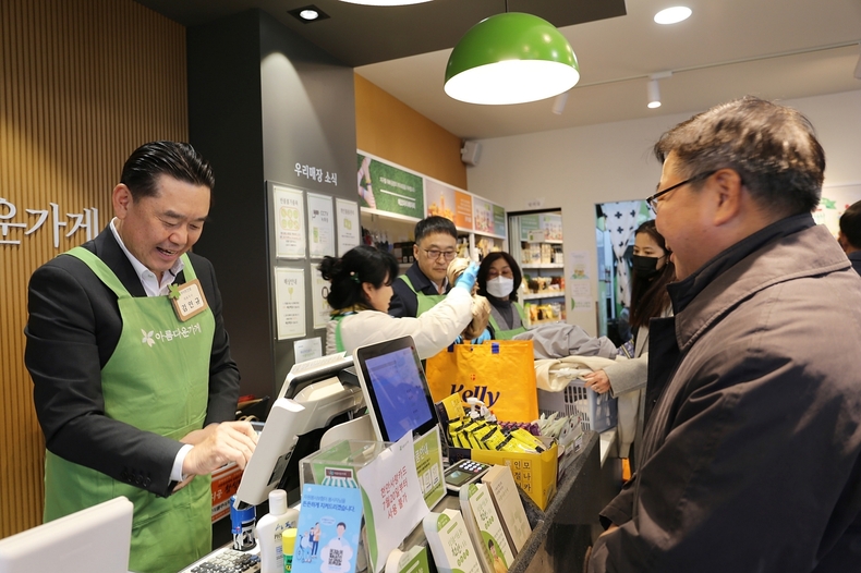 김인규 하이트진로 대표이사가 아름다운 하루 특별전서 판매 봉사를 하고 있다.