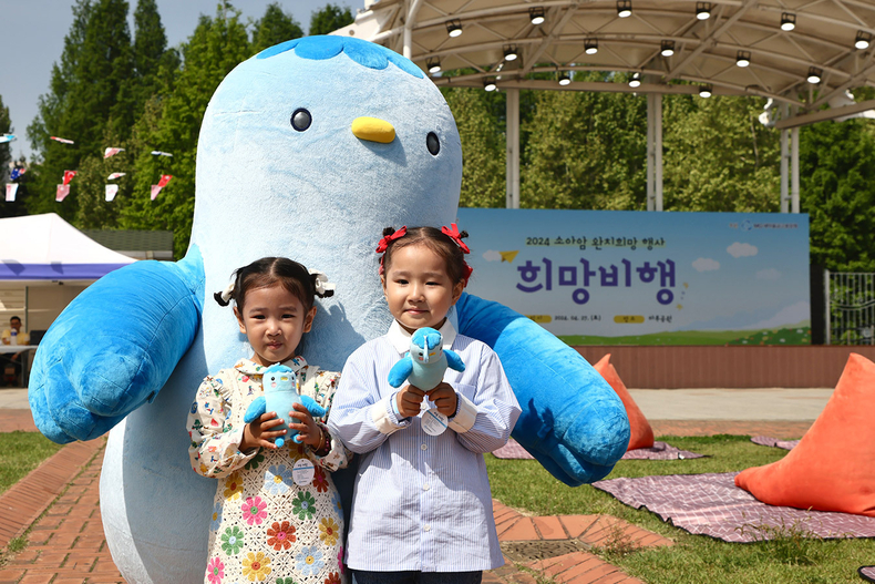 지난 27일, 서울 강남구 일원동 마루공원서 소아암 어린이 완치 희망행사에 참여한 어린이들이 새마을금고 블루원정대 캐릭터 미루와 사진촬영을 하고 있다.