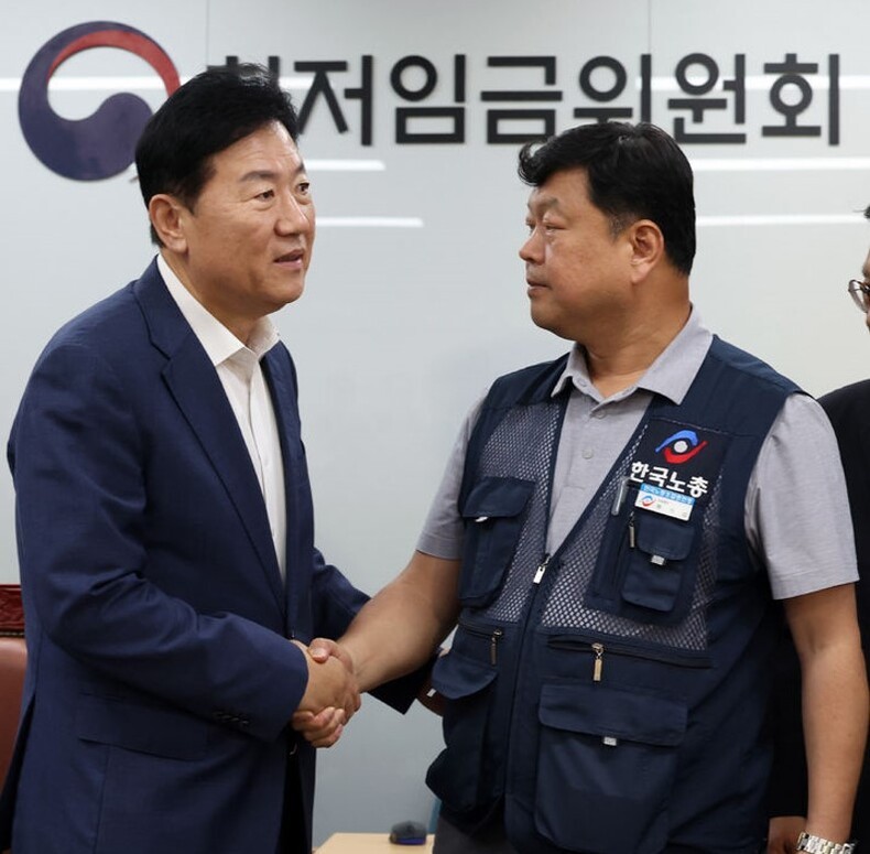 지난 10일, 최저임금 회의가 끝난 후 류기정 사용자 위원(사진 왼쪽)과 류기섭 근로자 위원이 악수하고 있다. ⓒ뉴시스