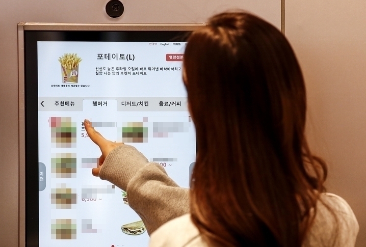 프랜차이즈 매장에서 키오스크로 주문 중인 고객 ⓒ뉴시스