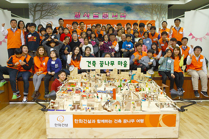 한화건설 김영수 전무(사진 앞에서 두번째줄 중앙)와 한양대 건축학부장 서현 교수(사진 오른쪽), 서울특별시 꿈나무마을 강효봉 원장(사진 왼쪽)이 ‘건축 꿈나무 육성 사회공헌활동’ 업무협약을 체결하고 꿈나무 마을 어린이들을 비롯한 한화건설-한양대 연합봉사단과 기념촬영을 하고 있다.