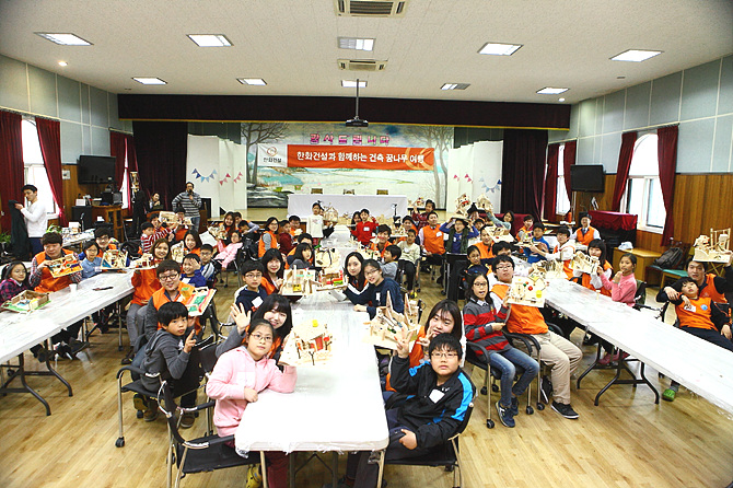 한화건설, 한양대 봉사단과 서울특별시 꿈나무마을 어린이들이 건축 모형 만들기 활동 후 단체사진을 촬영하고 있다.