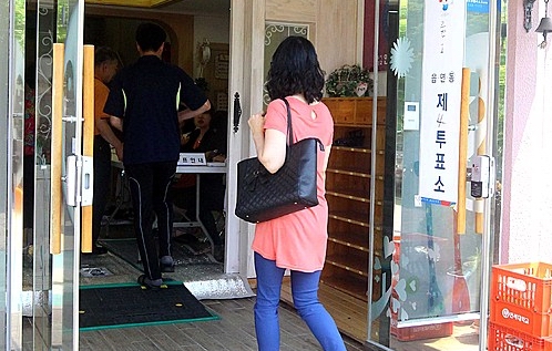 세월호 침몰사고로 많은 희생자가 발생한 경기 안산시 고잔동의 한 투표소에 4일 오후, 한 유권자가 투표를 위해 들어서고 있다. <사진=뉴시스>