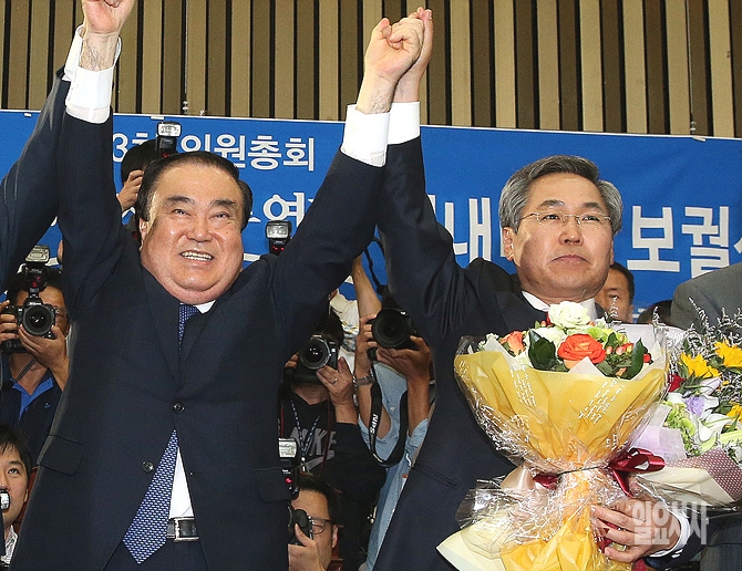 '꽃을 든 남자' 새정치민주연합 우윤근 신임 원내대표(사진 오른쪽)이 지난 9일, 서울 여의도 국회에서 열린 원내대표 보궐선거에서 이종걸 의원을 따돌리고 문희상 비상대책위원장과 손을 번쩍 치켜들고 있다. <사진=일요시사 DB>