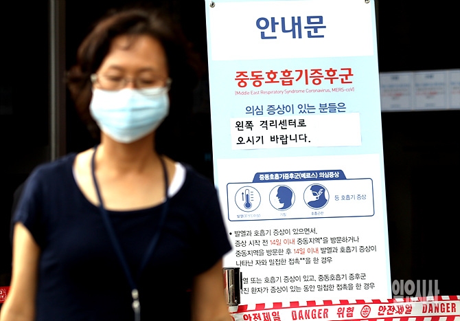 최근 중동호흡기증후군(MERS)이 전국적으로 확산되고 있는 가운데, 한 시민이 마스크 차림으로 서울 종로구 연건동 서울대병원을 지나고 있다.