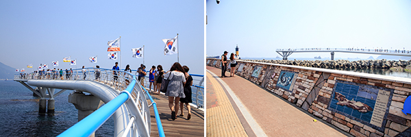 송도 구름산책로를 걷는 사람들 / 거북섬과 관련한 재미난 이야기들이 적힌 해안가 벽면