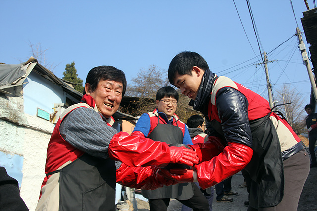 롯데건설 김치현 대표이사(왼쪽)가 임직원과 함께 연탄나눔봉사 활동을 하고 있다.