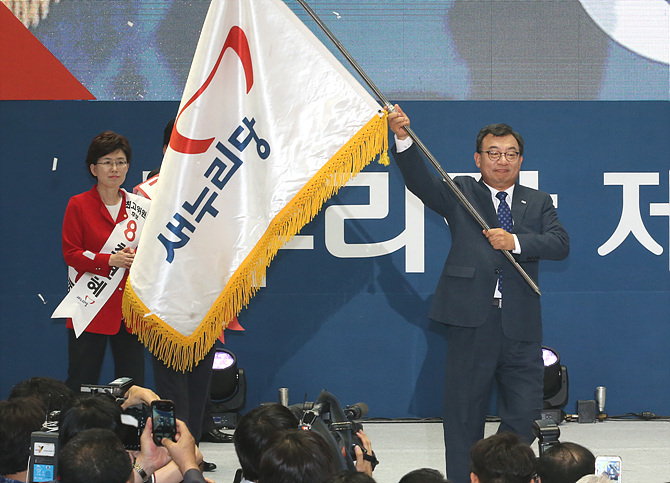 지난 9일, 서울 송파구 잠실실내체육관서 열린 새누리당 8·9 전당대회서 이정현 후보가 당선을 확정지은 후 당기를 이양 받아 들고 있다.