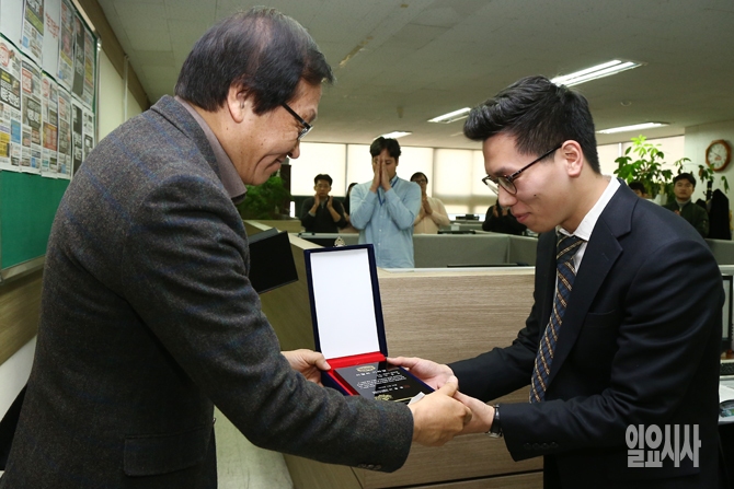 본지 이용범 발행인이 28일, 이달의 기자상 시상식에서 박창민 기자에게 상패를 수여하고 있다.