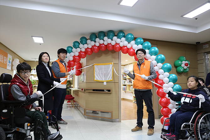 한화건설 봉사단과 관계자들이 22일, 경기도 광주 SRC보듬터에서 꿈에그린 도서관 60호점 개관을 축하하고 있다.