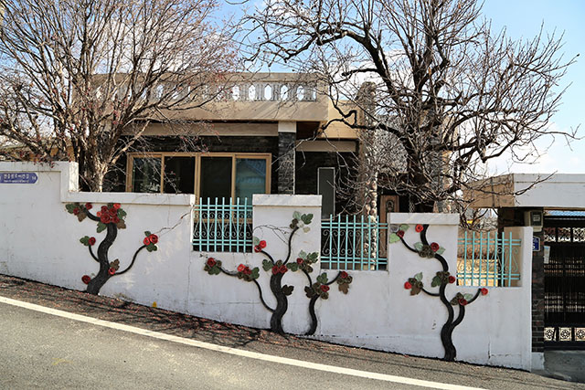 현충원역 3·4번 출구에서 만나는 벽화거리 새마을동네. 집 마당의 나무와 벽화가 어우러진다.