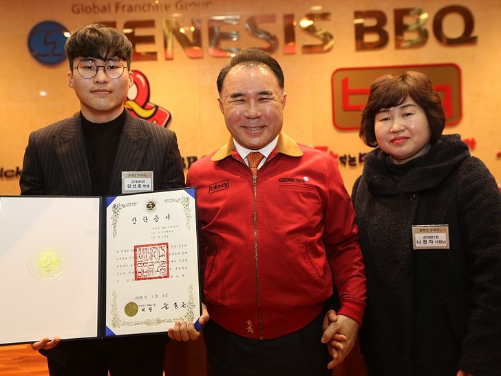 제너시스BBQ 그룹 윤홍근 회장(사진 가운데)과 BBQ 신대방1점 패밀리가 기념촬영을 갖고 있다.