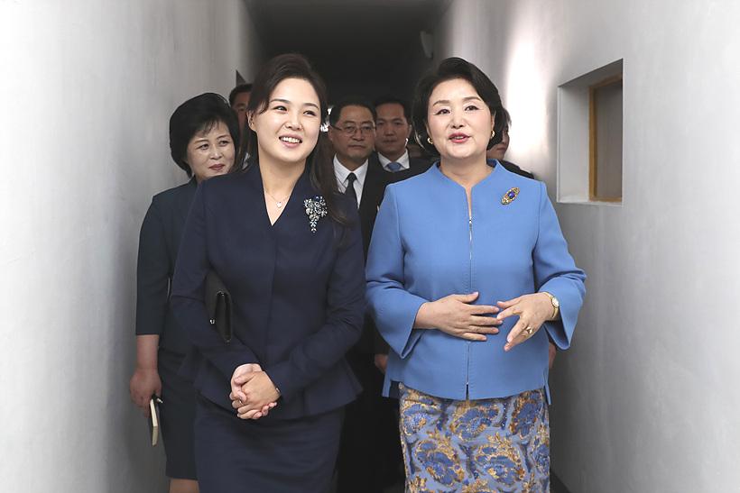 김정숙(사진 오른쪽)·리설주 여사가 지난달 18일, 김원균명칭 음악종합대학을 방문해 대화하며 이동하고 있다. <평양사진공동취재단>