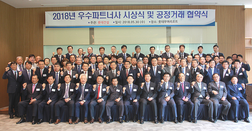 롯데건설 주요 임직들과 주요 파트너사 대표들이 우수파트너사 시상식 및 공정거래 협약식 행사를 기념하여 단체 촬영을 갖고 있다.