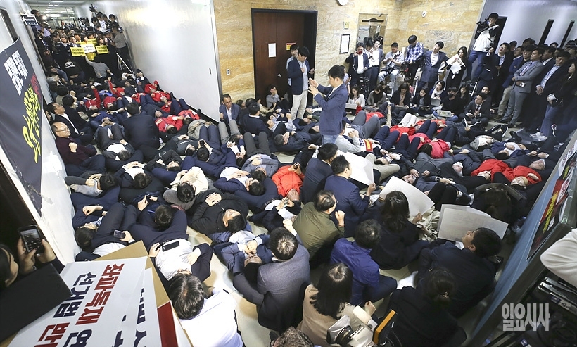 제5회의장 앞에서 스크럼을 짜고 있는 자유한국당 의원들 ⓒ사진공동취재단 ▲ 제5회의장 앞에서 스크럼을 짜고 있는 자유한국당 의원들 ⓒ사진공동취재단
