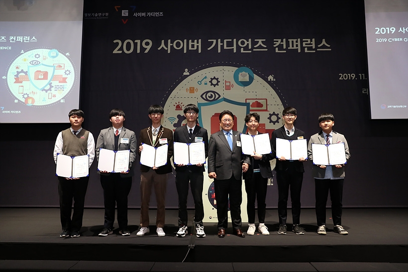 29일, 서울 구로 라마다 서울 신도림 호텔서 열린 사이버 가디언즈 컨퍼런스서 사이버 가디언즈 주니어 임명장을 수여받은 학생들과 한국정보기술연구원 유준상 원장이 기념촬영을 갖고 있다. (사진왼쪽부터 이주창, 구지원, 김윤환, 김정진, KITRI 유준상 원장, 신현빈, 문조영, 이준석) ▲ 29일, 서울 구로 라마다 서울 신도림 호텔서 열린 사이버 가디언즈 컨퍼런스서 사이버 가디언즈 주니어 임명장을 수여받은 학생들과 한국정보기술연구원 유준상 원장이 기념촬영을 갖고 있다. (사진왼쪽부터 이주창, 구지원, 김윤환, 김정진, KITRI 유준상 원장, 신현빈, 문조영, 이준석)