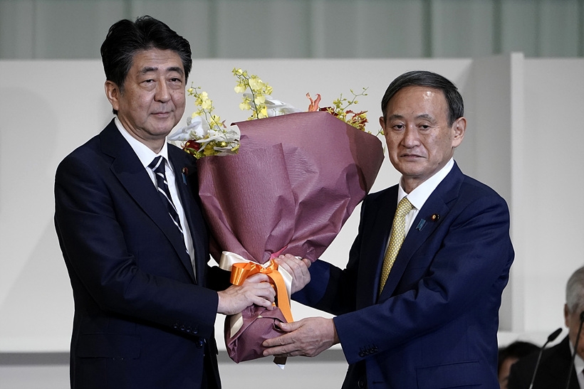 아베 전 일본 총리로부터 꽃다발 건네 받는 스가 요시히데 신임 총리(사진 오른쪽) ▲ 아베 전 일본 총리로부터 꽃다발 건네 받는 스가 신임 총리