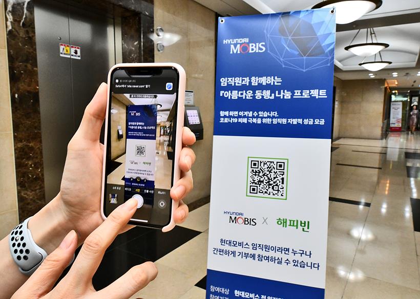 현대모비스 직원이 모바일 QR코드 방식으로 코로나19 피해 극복을 위한 자발적 기부 캠페인에 참여하고 있다. ▲ 현대모비스 직원이 모바일 QR코드 방식으로 코로나19 피해 극복을 위한 자발적 기부 캠페인에 참여하고 있다.