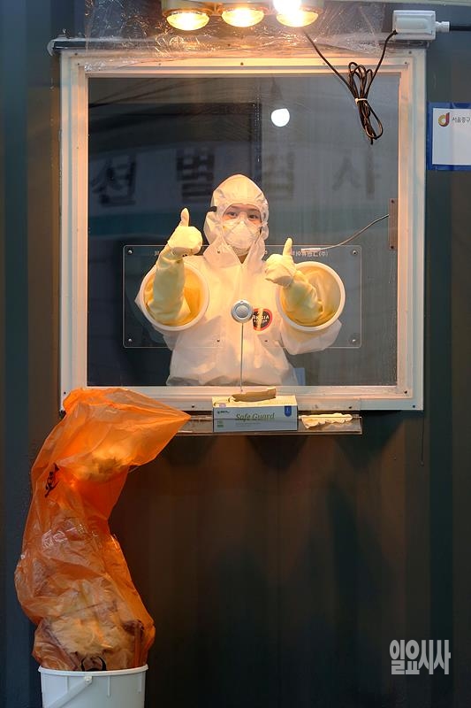 “함께 이겨내요!” 지난달 26일, 서울역 광장에 설치된 코로나19 임시선별진료소서 한 의료진이 취재진을 향해 파이팅 포즈를 취해주고 있다. ▲ ▲